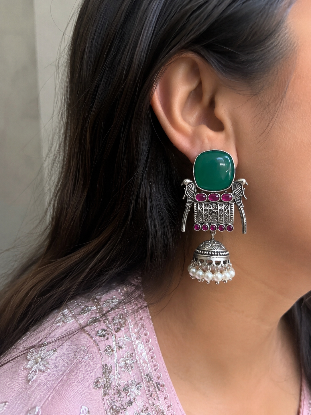 Emerald green stone jhumka earrings worn on model - close up side view
