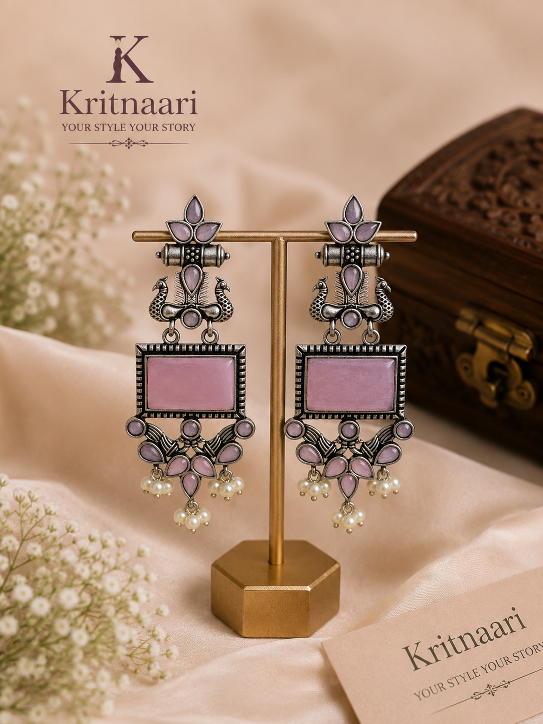 Oxidised silver peacock rectangular stone earrings in emerald green held in hand